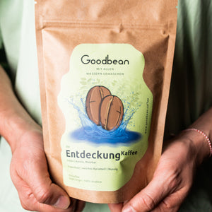 Die Entdeckung Kaffee von Goodbean, säurearme Kaffeetüte in den Händen